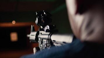 Shooting gallery client hitting paper targets with ammo, extreme close up of rifle. Close up of person at firing range establishment shooting bullseyes, enjoying using semiautomatic weapon, camera A video