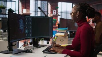 IT technician in startup office using large language model to get help with coding project. IT specialist interacting with AI LLM chatbot on PC in software development business company, camera A video