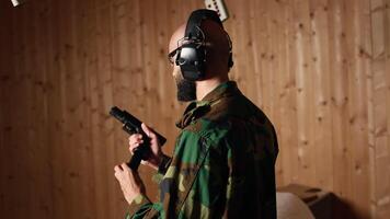 Man in firing range shooting targets with pistol doing face palm after missing. Disappointed person training with weapon feeling upset after failing to hit bullseyes, camera A video