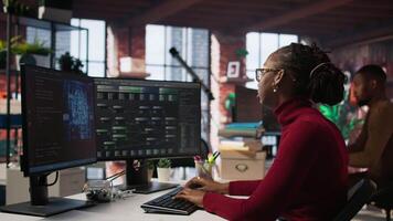 Exhausted AI startup employee rubbing forehead while analyzing datasets on computer, receiving coffee from project CTO manager to get energy and continue coding, camera A video