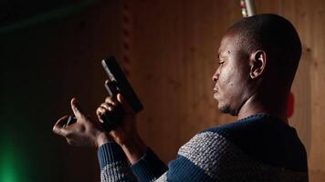 Shooting range customer reloading pistol, preparing to shoot targets during recreational sport activity. Man at firing range location loading pistol with ammunition, camera A close up video