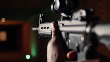 Man holds assault rifle, enjoying recreational shooting experience in firing range. Person practices with semiautomatic weapon in safe environment at shooting range company, camera A extreme close up video