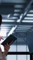 Vertical Colleagues in data center workplace use laptop to calibrate energy usage. Server farm IT specialist using notebook to inspect UPS configurations, doing maintenance on equipment, camera A video