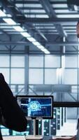 Vertical Manager meeting with client in data center using artificial intelligence tech, reaching deal. People doing handshake in AI based server farm after checking files and finishing transaction, camera B video