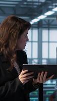 Vertical Computer scientists in data center using tablet to develop disaster recovery plans. IT professionals in server farm discussing, testing failover scenarios, protecting data during disruptions, camera A video