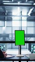 Vertical Programmers in data center brainstorming, using mockup tablet, observing equipment analytics. Server hub IT coworkers use isolated screen device, adjusting system parameters, camera B video
