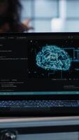 Vertical Artificial intelligence technology coding on laptop in data center with programmers in background employing machine learning models. Notebook used by AI IT experts, camera A close up video