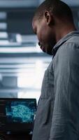 vertical Programas desenvolvedores dentro dados Centro usando computador portátil, empregando ai máquina Aprendendo modelos. trabalhadores usando caderno para Preencha artificial inteligência a infraestrutura precisa, alocando recursos, Câmera uma video