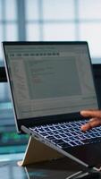 Vertical Engineer in data center with laptop automating routine maintenance tasks, executing diagnostic scripts. Man coding on notebook, adjusting power settings, validating server configurations, camera A video