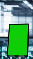Vertical Close up of mockup tablet and data center engineers developing disaster recovery plans. Focus on isolated screen device in front of server farm colleagues testing failover scenarios, camera B video