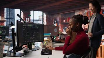 CTO supervisor in bringing coffee mug to tired worker debugging applications in artificial intelligence focused startup. Team leader helping overworked employee with caffeine beverage, camera A video