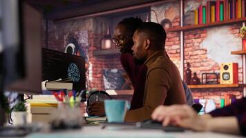 Startup staff members gathered together to conduct code review to fix bugs, identifying technical issues. Artificial intelligence company coworkers doing brainstorming, optimizing code, camera B video