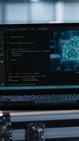 Vertical Laptop in front of data center engineers in background deploying artificial intelligence tools. AI coding on notebook screen next to technicians inspecting server clusters, camera A close up video