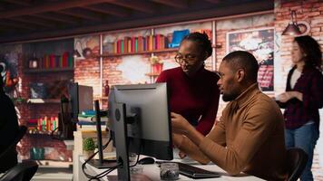 Coworkers looking at PC screen in startup office, managing cloud computing resources and platforms to train machine learning models. Teamworking colleagues monitoring venture company systems, camera A video