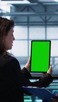 Vertical Computer scientists in data center use mockup tablet, inspecting server rigs, updating devices. Teamworking IT colleagues collaborating to ensure stable operations, using chroma key device, camera A video