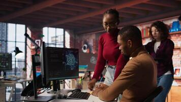 Teamworking startup engineers writing message on sticky notes while coding advanced AI algorithm. Coworkers in artificial intelligence Silicon Valley workspace leaving memo on PC screen, camera A video