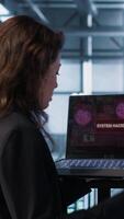 Vertical Woman panicking after seeing data center getting attacked by hackers trying to steal data. Technician in server farm seeing errors on laptop screen, struggling to contain virus infestation, camera A video