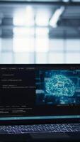 Vertical Focus on laptop used by teamworking data center computer scientists in background using artificial intelligence. Notebook screen with neural networks doing computing processes, camera B close up video