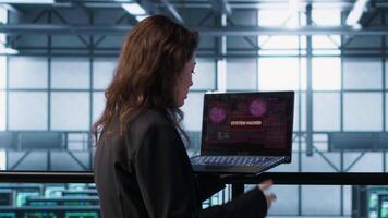 Woman panicking after seeing data center getting attacked by hackers trying to steal data. Technician in server farm seeing errors on laptop screen, struggling to contain virus infestation, camera A video