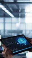 Vertical Close up of computer scientist in data center uses AI on tablet, verifying compliance of racks. IT expert using artificial intelligence on device to optimize resource utilization, camera B video