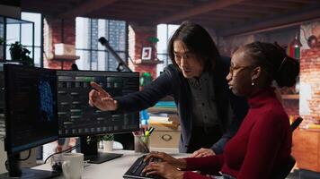 Man in AI startup office CTO position overseeing software engineer implementing machine learning. Artificial intelligence tech venture supervisor helps employee fix code bugs, camera A video