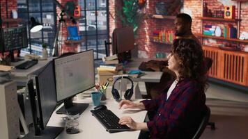 Engineers cooperating in startup office, using programming languages on PC to build applications. Coworkers doing brainstorming, using computer in software development agency to code, camera A video