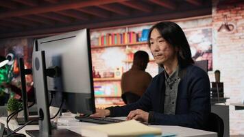 Startup manager leveraging machine learning technology in office to gain competitive edge. Asian Silicon Valley company IT expert working on rapid technological advancement, camera A video