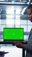 Vertical Engineering team in data center using green screen laptop, implementing predictive analytics scripts, reviewing equipment health, adjusting system parameters, coordinating maintenance tasks, camera B video