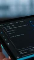 Vertical Programmer in data center using AI on tablet, verifying compliance requirements of supercomputers. Server hub worker optimizing resource utilization using device, camera A close up video