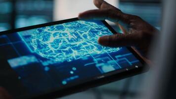 Close up of computer scientist in data center uses AI on tablet, verifying compliance of racks. IT expert using artificial intelligence on device to optimize resource utilization, camera A video