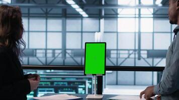 Inspector checking documents in server hub to ensure compliance with industry standards, using mockup tablet. Admin team inspecting files, overseeing data center workplace security protocols, camera A video