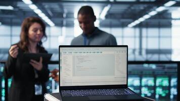 linhas do código em computador portátil exibição usava de trabalho em equipe dados Centro colegas para corre segurança patches. programação língua em caderno usava de servidor quarto isto experts digitalização engrenagem, Câmera b fechar acima video