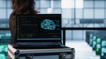 Artificial intelligence technology coding on laptop in data center with programmers in background employing machine learning models. Notebook used by AI IT experts, camera A close up video