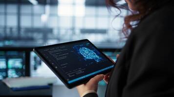 Data center technician using artificial intelligence on tablet to prevent vulnerabilities. Employee using device to review firewall rules, enforcing AI cybersecurity protocols, camera B close up video