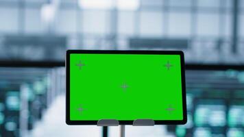 Close up of chroma key tablet and teamworking programmers in server room adjusting power management settings. Focus on isolated screen mockup device in front of data center technicians, camera A video
