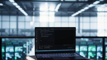 Laptop used by data center system administrators using artificial intelligence tech, handheld camera shot. AI programming language on notebook used by server farm employees, camera B close up video
