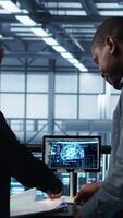 Vertical Manager meeting with client in data center to review files, doing handshake after finalizing deal. Server room supervisor reaching agreement with customer after checking documentation, camera B video