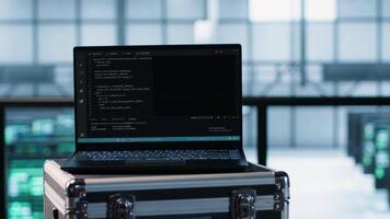 Laptop used by data center system administrators using artificial intelligence tech, handheld camera shot. AI programming language on notebook used by server farm employees, camera A close up video