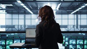 Technician in data center using AI tech on tablet to adjust power management settings. Engineer in server room optimizes resource utilization using artificial intelligence, camera B video