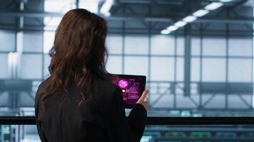 Data center engineer stressed by cyberattack affecting devices, trying to protect critical systems. Server room admin receiving threat detection alert on device, camera A video