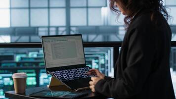 Technician using laptop in data center, finetuning network protocols, holding coffee cup. Woman in server room coding on notebook, enforcing advanced security measures, camera A video