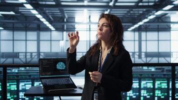 Technicians in high tech AI data center workspace looking at hologram visualization. Programmer working on securing server room hardware using AR artificial intelligence tech, camera B video
