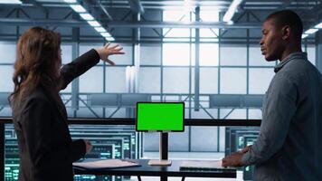 Data center team using mockup green screen tablet, reviewing paperwork files, and security protocols. Server room admins next to chroma key device analyzing critical system reports, camera A video
