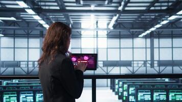 Data center engineers struggling to contain virus infestation, working on securing servers. Team of server farm employees detecting hacker attacks on tablet, fighting back, camera B video