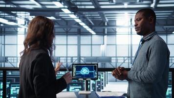 Team of engineers in data center with tablet integrating AI driven automation tools, doing maintenance. Teamworking colleagues in server room using artificial intelligence, camera B video