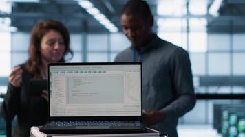 linhas do código em computador portátil exibição usava de trabalho em equipe dados Centro colegas para corre segurança patches. programação língua em caderno usava de servidor quarto isto experts digitalização engrenagem, Câmera uma fechar acima video