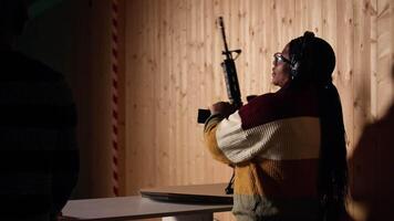 Shooting gallery client using rifle to hit targets, getting congratulated by instructor after great result. Woman doing thumbs up after receiving compliments for shooting bullseye, camera A video