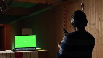 Chroma key notebook and shooting range customer reloading pistol, shooting targets. Isolated screen laptop next to man at shooting ground facility loading pistol, wearing protection goggles, camera A video