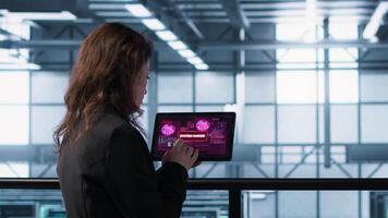 Data center engineers struggling to contain virus infestation, working on securing servers. Team of server farm employees detecting hacker attacks on tablet, fighting back, camera A video
