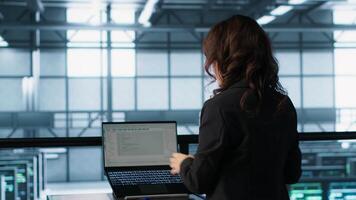 Technician in data center using AI tech on tablet to adjust power management settings. Engineer in server room optimizes resource utilization using artificial intelligence, camera A video